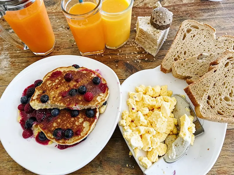blueberry pancakes and scrambled eggs with toast and orange juice